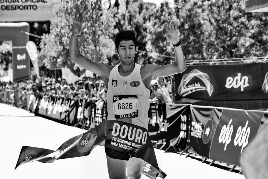 Triumphant athlete crossing the finish line at Douro half marathon in a vibrant race.
