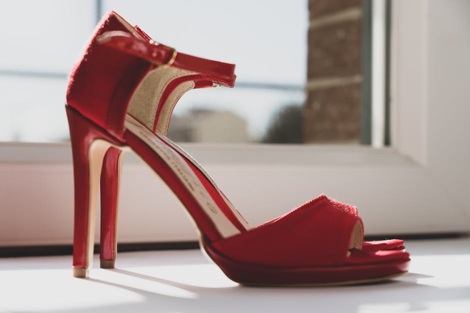 A stylish photo of red high heels by a window capturing elegance and fashion essence.
