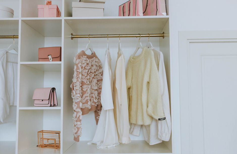 Neat closet showcasing white and pink clothes and accessories for a chic, clean look.