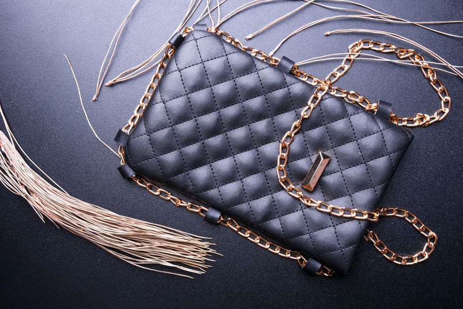 Stylish black purse with a quilted pattern and golden chain strap, showcasing elegance.