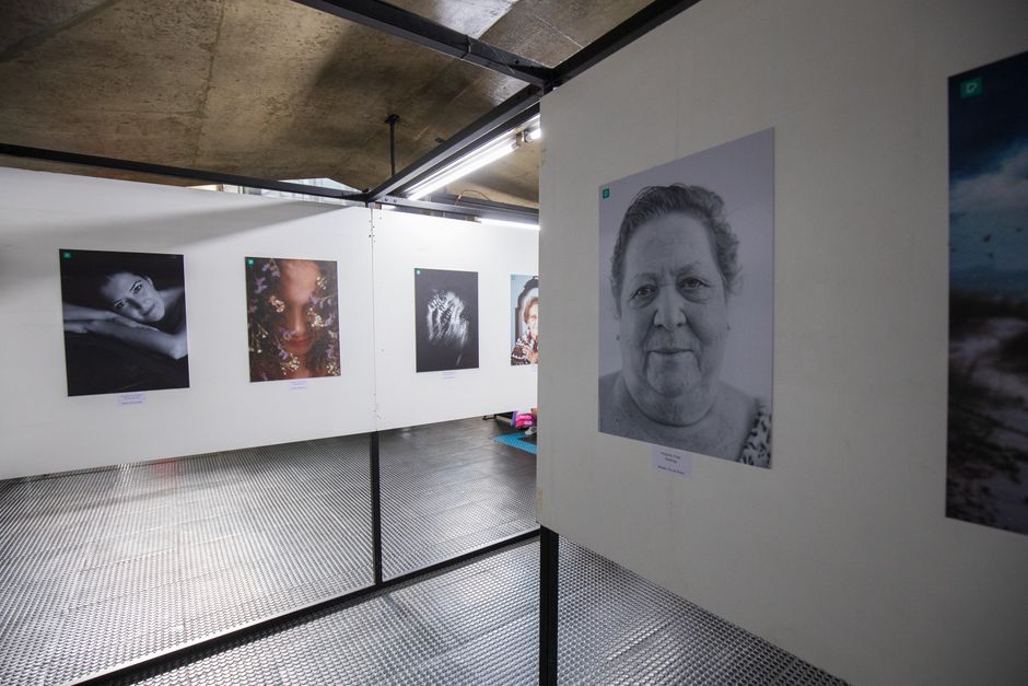 Interior view of an art gallery with portrait photographs on display.