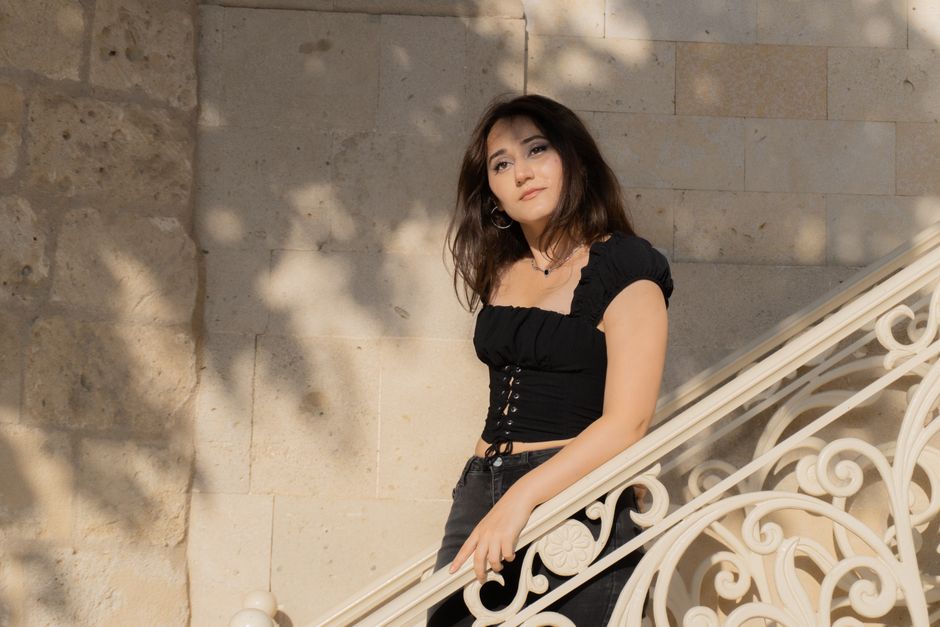 Portrait of a young woman leaning on a decorative staircase in Baku, Azerbaijan.
