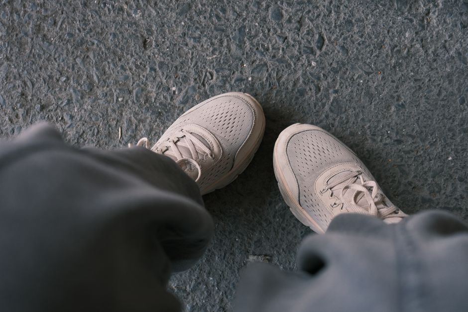 Casual white sneakers pictured on a textured pavement, perfect for lifestyle and fashion themes.